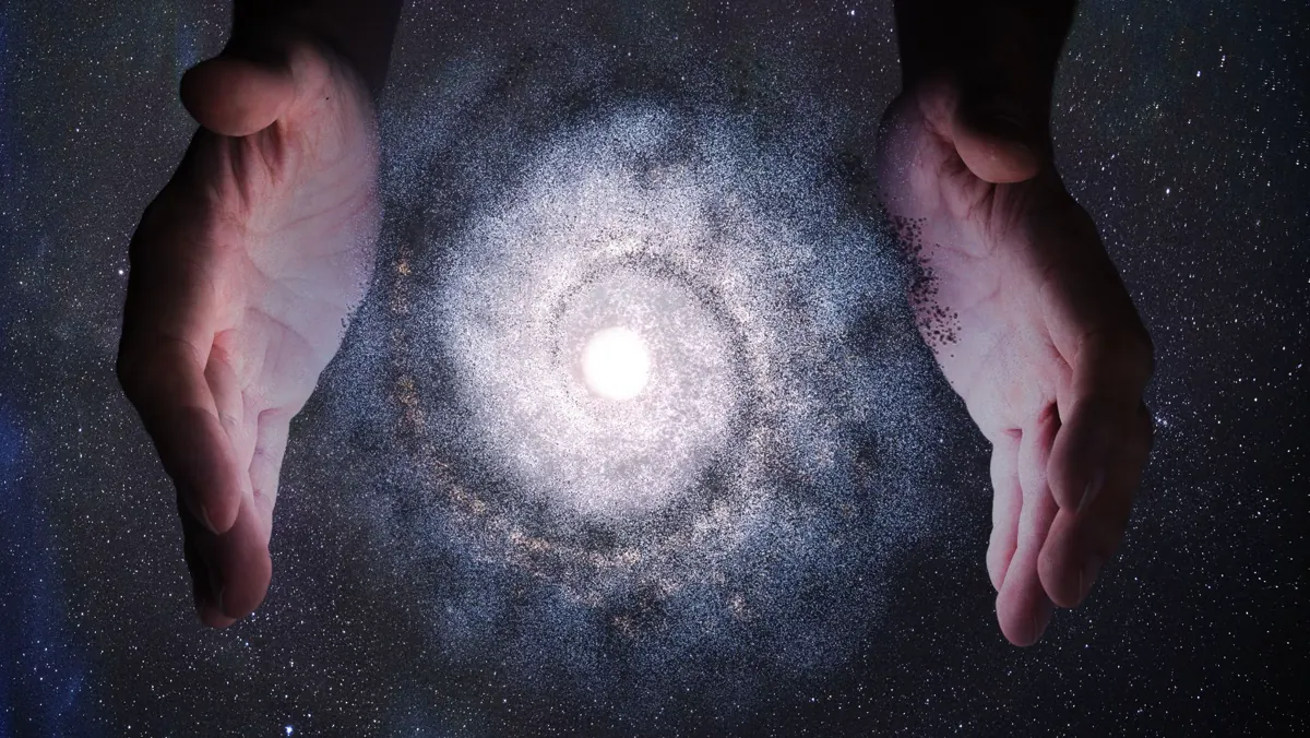 Due mani attorno a una galassia luminosa