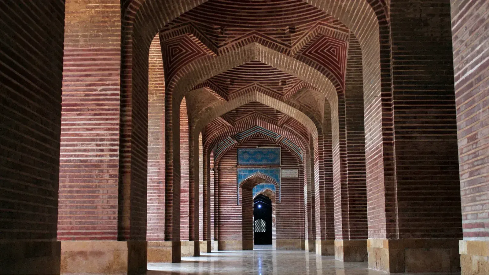 Corridoio di archi in mattoni rossi con la geometria sacra nelle moschee antiche