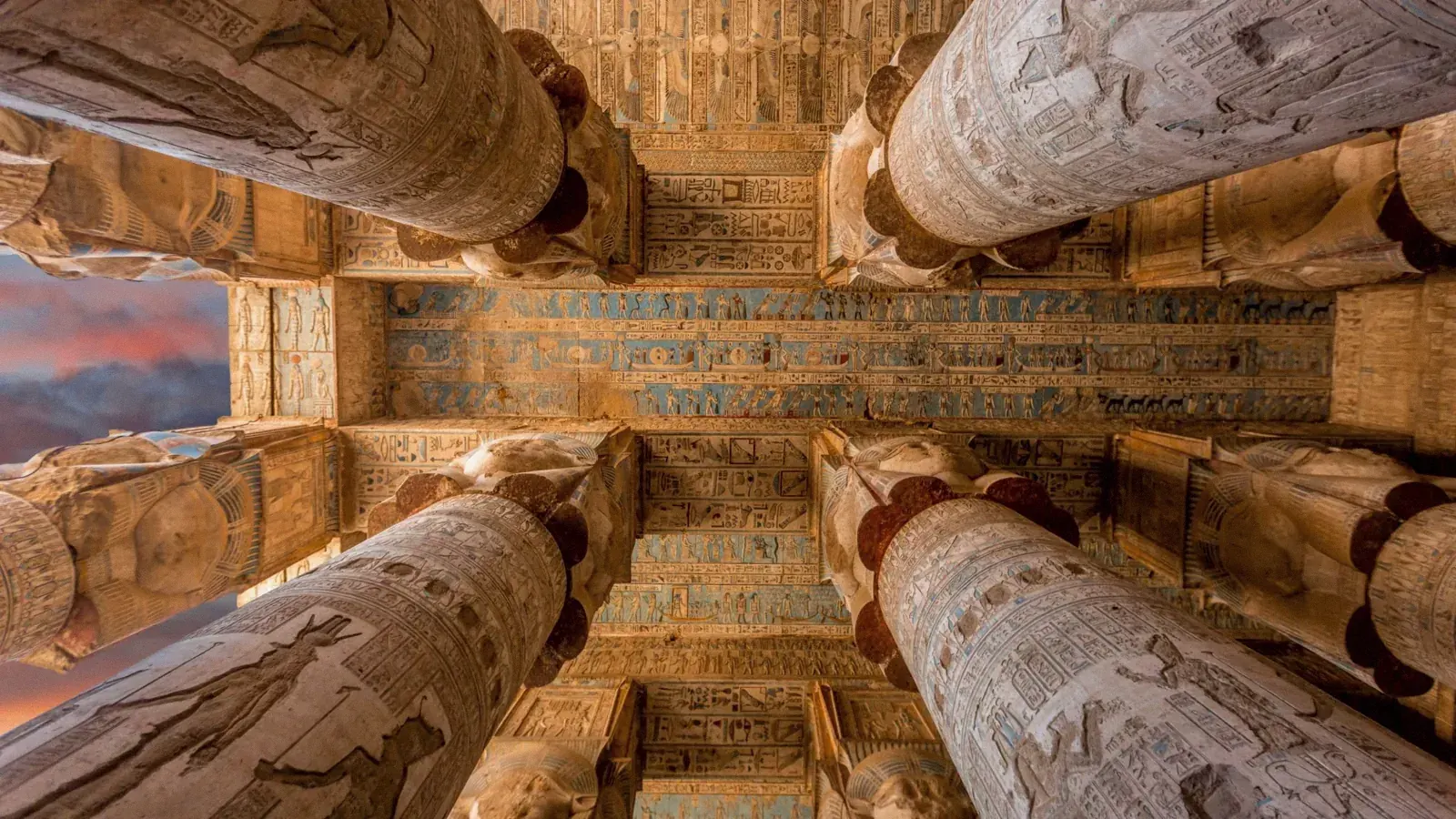 Colonne di Hathor e soffitto dipinto di blu e oro nel tempio di Dendera, viste dal basso