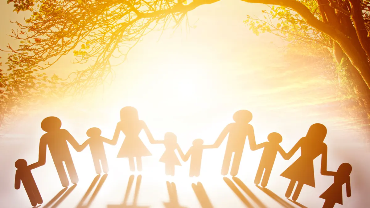 Sagome di una famiglia che si tiene per mano nella luce